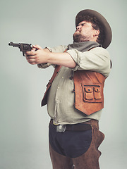 Image showing Cowboy, western man and shooting gun, weapon and pistol in studio with costume isolated on a white background. Plus size, criminal and male person with revolver, aim and scared with fear in Texas