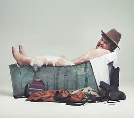 Image showing Cowboy, studio and bathtub with comic bandit, naughty and plus size man on white background. Retro, wild west and male model in metal tub, grin and smoking cigar while bathing with mockup space