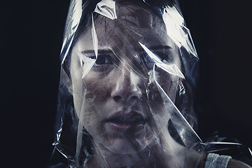 Image showing Plastic, woman and bag on face with scary drama in studio, dark background or afraid of death. Suffocation, murder and girl with fear from crime, victim and trapped in trash, garbage or pollution