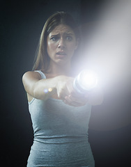 Image showing Woman, fear and horror or flashlight for search in studio, anxiety and stress for risk in mystery. Female person, nervous and lamp in dark against black background, caution and danger on halloween