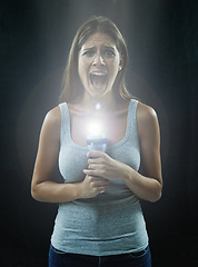 Image showing Woman, portrait and scared or flashlight for scream in studio, anxiety and stress for risk in mystery. Female person, shout and lamp in dark against black background, caution and danger or horror