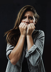 Image showing Portrait, horror and woman biting nails in studio on black background for reaction to fear or terror. Face, anxiety and mental health with scared young person in dark for stress, phobia or nightmare