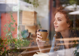 Image showing Woman, coffee and thinking by window in cafe with book for creative idea, reading inspiration and knowledge. Person, freelancer and thoughtful with beverage in diner for research motivation and study