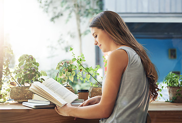 Image showing Book, coffee shop and relax with woman reading at table as customer for break, caffeine or literature. Cafe, flare or knowledge and young person at window in restaurant with novel or story on weekend