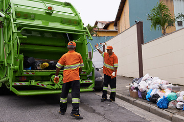 Image showing Trash, people and working with garbage truck for waste management, service and maintenance. Urban, cleaning and men outdoor with industrial sanitation, collection of rubbish and infrastructure