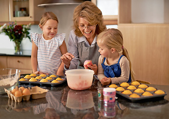 Image showing Grandma, children and smile for teaching, baking and decorating for family, play and bonding at home. Happy, pensioner and girl with cupcake, laugh and icing for creative fun together in kitchen