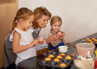 Image showing Grandmother, child and cupcake helping in kitchen or icing decorations or sprinkles or sweet treat, bonding or teaching. Female person, siblings and baking ingredients or learning, dessert or recipe