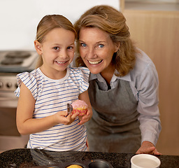 Image showing Portrait, baking and girl with grandmother in kitchen of home for growth, learning or child development. Family, smile and cupcake with senior woman teaching granddaughter how to bake in apartment