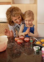Image showing Woman, child and cupcake sprinkles for baking decoration in kitchen for learning support or sweet snack, proud or ingredients. Grandmother, girl and icing recipe at home for teaching, help or happy