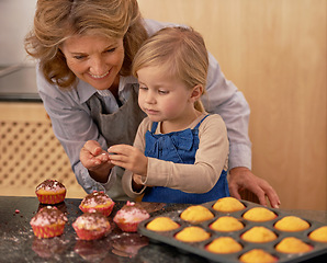 Image showing Grandmother, child and baking cupcakes or decorating with icing or learning creativity, bonding or teamwork. Female person, girl and sweet treats or teaching with ingredients, dessert or sprinkles