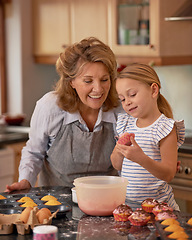 Image showing Elderly woman, girl and smile for teaching, baking and bonding together at weekend in family home. Happy, senior citizen and child with cupcake, ecourage and icing for creative fun in kitchen