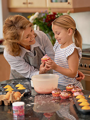 Image showing Grandmother, child and cupcake decorating in kitchen with icing or sprinkles or creativity, bonding or teamwork. Female person, girl and sweet treats or teaching with dessert ingredient, snack or fun