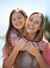 Image showing Mother, child and portrait with outdoor hug or relax holiday with blue sky in summer, bonding or connection. Female person, daughter and face with embrace in California for love, caring or parenting