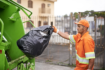 Image showing Cleaning, waste management and garbage truck with man in uniform throwing black bag outdoor on city street. Job, service and trash with serious person working for sanitation or collection of dirt