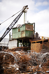 Image showing Crane, machine and scrapyard for moving metal with sustainability, manufacturing or stop pollution. Vehicle, tractor and outdoor in junkyard, plant or ecology for iron, steel industry and environment