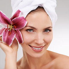 Image showing Skincare, portrait and woman with towel, flower and spa treatment with cosmetics in studio. Dermatology, healthy skin and girl on white background with luxury salon facial, morning and natural beauty