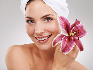 Image showing Beauty, portrait and woman with towel, flower and spa treatment with cosmetics in studio. Dermatology, healthy skin and girl on white background with luxury salon facial, morning and natural skincare