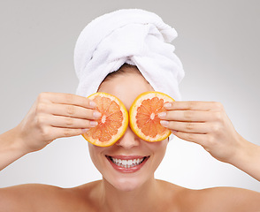 Image showing Skincare, face and woman with towel, grapefruit and spa treatment with cosmetics in studio. Dermatology, healthy skin and girl on white background with luxury facial, vitamin c and natural beauty.