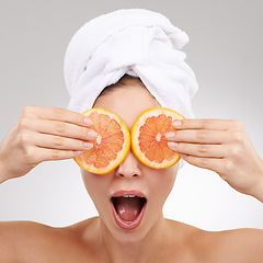 Image showing Skincare, wow and woman with towel, grapefruit and spa treatment with cosmetics in studio. Dermatology, healthy skin and face of girl on white background with shock, vitamin c and natural beauty.