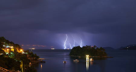 Image showing Thunderstorm, sea and land with bad weather, nature and raining with storm and New York city. Clouds, climate change or ocean with lightning or night with warning or island with winter, dark or water