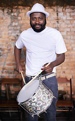 Image showing Portrait, drums or carnival with a black man playing an instrument in a festival in Rio de Janeiro. Brazil, ready or party with a male musician, performer or artist banging on a drum to create a beat