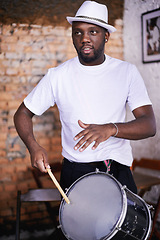 Image showing Performance, drum or carnival with a black man playing an instrument in a festival in Rio de Janeiro. Brazil, rhythm or party with a musician, performer or artist banging to create a beat in show