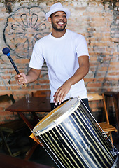 Image showing Music, drums or carnival with a happy man playing an instrument in a festival in Rio de Janeiro. Brazil, smile or party with a male musician, performer or artist banging on a drum to create a beat