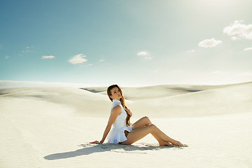 Image showing Portrait, fashion and woman with vacation, sand and weekend break with dune, relax and getaway trip. Blue sky, person and girl with holiday and pose with adventure and outdoor with nature and desert