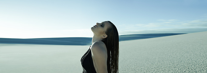 Image showing Woman, fashion and dune in desert for aesthetic with edgy style, dress or mystery in nature sunshine. Girl, person and model with thinking on sand, hill or profile by horizon with memory in summer