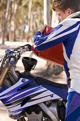 Image showing Motorcycle, sports and man pouring gas in preparation of competition, race or training outdoor in forest. Bike, hobby and getting ready with young athlete in nature for action, adrenaline or fuel