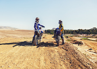 Image showing Sport, racer or relax on motorcycle outdoor on dirt road with blue sky for driving, challenge or competition. Gear, motorbike or dirtbike driver with helmet on offroad course or path for racing