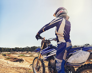 Image showing Motorbike, sports and danger with back view of biker person outdoor, sunl with uniform for riding on dirt track. Speed, power and risk with motorcycle, transportation and adventure for adrenaline