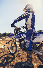 Image showing Motorcycle, extreme sports and danger with biker person outdoor, sunshine with uniform for riding on dirt track. Speed, power and risk with motorbike, transportation and adventure for adrenaline