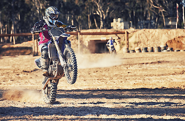 Image showing Motorcycle, action and balance with person riding on dirt track, adrenaline and stunt for extreme sports outdoor. Competition, adventure and power with risk, speed and biker on motorbike for race