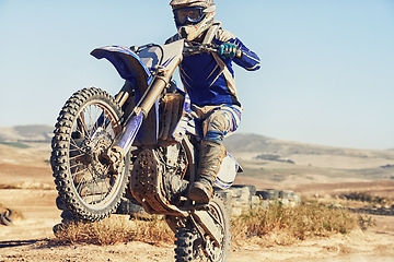 Image showing Motorbike, action and balance, person with speed and skill for adrenaline and stunt with extreme sports outdoor. Competition, adventure and power with risk, biker riding on motorcycle with wheelie