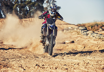 Image showing Person, motorcyclist and dust with motorbike on dirt track for race, extreme sports or outdoor competition. Professional or expert rider on bike, scrambler or sand course for off road rally challenge