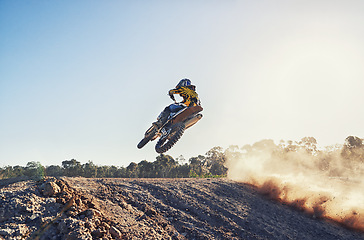 Image showing Person, jump and sports motorcyclist in the air for trick, stunt or race on outdoor dirt track. Rear view of expert rider on motorbike or scrambler in extreme adrenaline with blue sky on mockup space