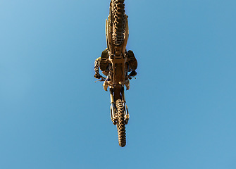 Image showing Motorcycle, jump and person on blue sky mockup with low angle for performance, extreme sports stunt and adrenaline. Competition, fearless and man on motorbike for outdoor challenge and skill.