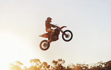 Image showing Person, jump and motorcyclist in the air with sunset on mockup for trick, stunt or ramp on outdoor dirt track. Expert rider on motorbike with lift off for extreme sports or rally challenge in nature