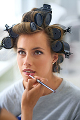 Image showing Woman, apply lipstick and beauty or curlers, grooming and rollers for hairstyle by makeup artist. Female person, mouth and hair treatment for volume, skincare and makeover for behind the scenes