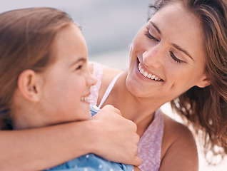 Image showing Happy mother, child and hug with love at beach for support, care or bonding on outdoor holiday or weekend in nature. Face of mom and young daughter with smile for embrace by the ocean coast or sea