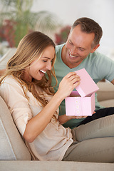 Image showing Woman opening present, man and happiness with surprise for birthday or anniversary, love and support with romance. Couple in marriage, unboxing package and gift giving for token of appreciation