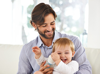 Image showing Father, baby and laughing while playing, feeding and love at home for child development and growth. Dad, parent and infant for fun, cheerful and family at house after work and nutrition and laugh