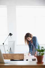 Image showing Business, woman and writing or planning at office desk for creative, project and startup on desktop or computer. A young worker or graphic designer with notes for website brainstorming and research