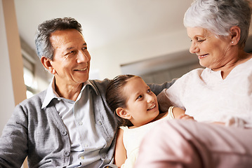 Image showing Home, smile and grandparents with grandchild in living room, together and love with happiness. Old people, grandmother and grandpa in house as seniors in retirement, elderly and bonding with girl