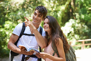 Image showing Couple, map and point for adventure in woods with smile for thinking, holiday or hiking on path. Man, woman or guide for trekking, direction or search in rainforest with book for location in Colombia