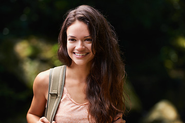 Image showing Walking, travel or happy woman in nature, woods or wilderness for trekking or outdoor adventure with bag. Smile, relax or hiker hiking in natural park or forest for exercise or wellness on holiday