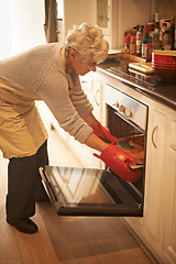 Image showing Senior woman, oven and cooking pie at home in kitchen for food, nutrition and dessert. Female person, elderly lady or retired baking pastry dish on tray, pan or stove for eating, dining and enjoyment