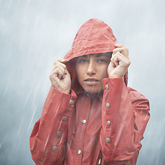 Image showing Woman, protection and portrait with rain, coat and clouds with safety in nature. Girll, face and storm with cloudy, winter and waterproof hat for confidence and weather with adventure or vacation