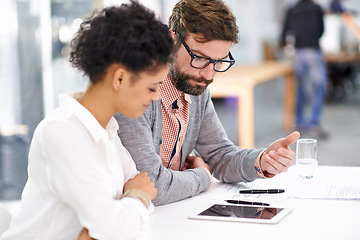 Image showing Business people, tablet and collaboration in meeting for teamwork, planning or discussion on table at office. Businessman and woman with documents and technology for project or research at workplace